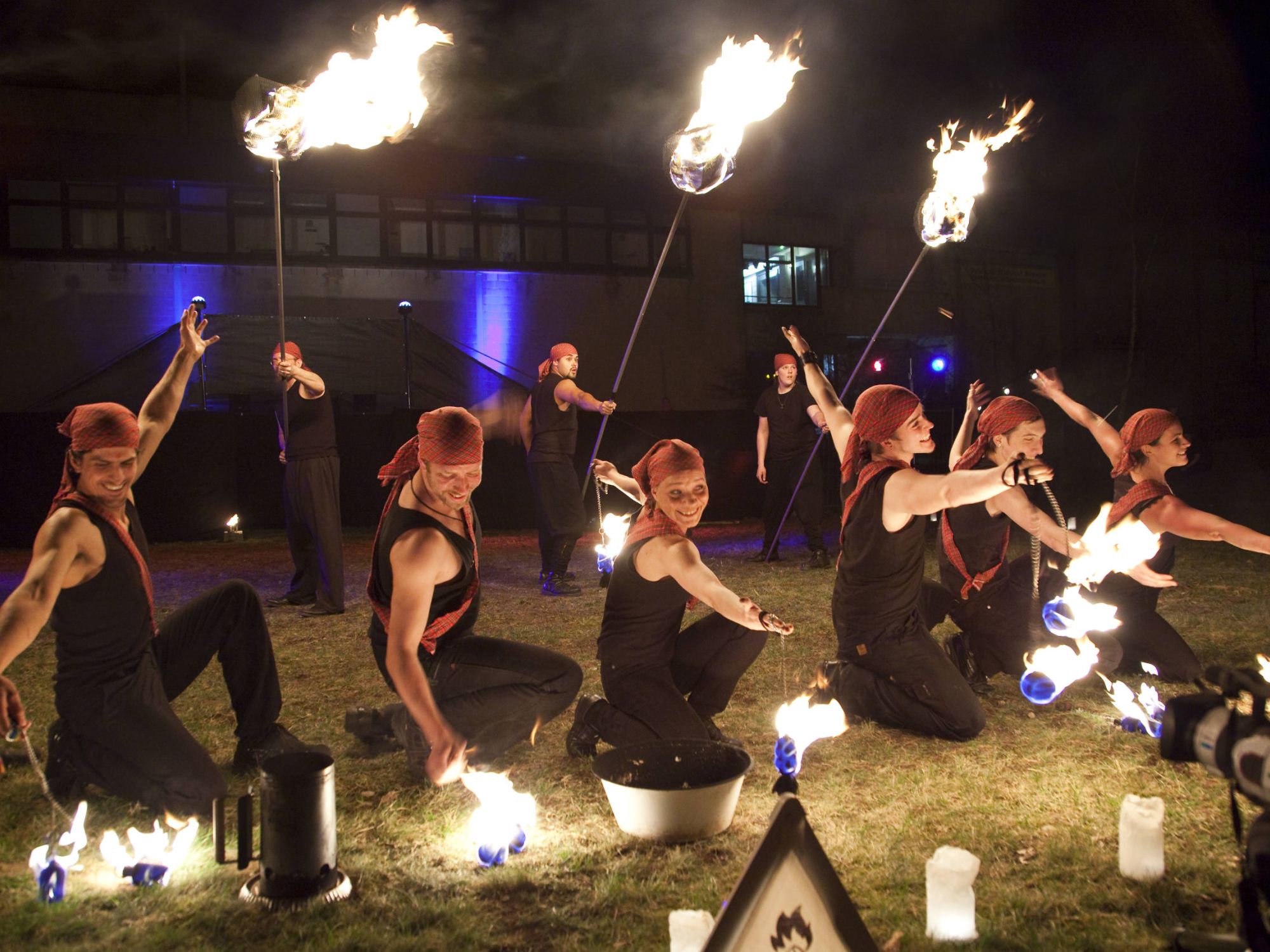 Feuerkünstler*innen mit brennenden Requisiten beim Abschluss-Applaus